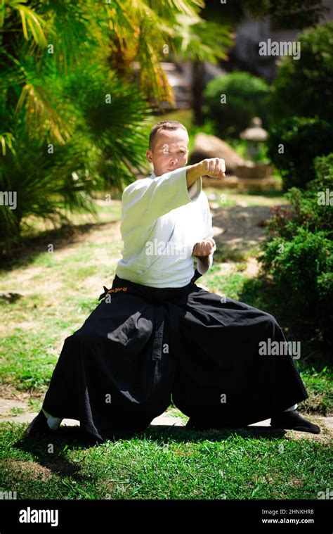 Young serious man aikido master in traditional costume Stock Photo - Alamy