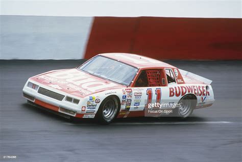 Darrell Waltrip races around the track in his Budweiser stock car... News Photo - Getty Images