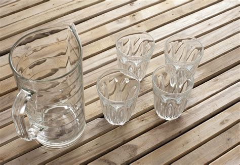 Clean transparent glass jug and four tumblers - Free Stock Image