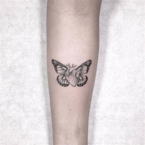 Micro-realistic butterfly heart tattoo on the inner