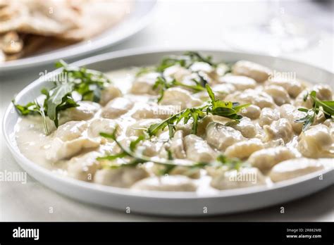 Gnocchi ai quattro formaggi, Italian dough pasta with four types of cheese and ruccola on top ...