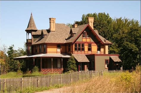 an old style house in the middle of a field with tall grass and trees ...