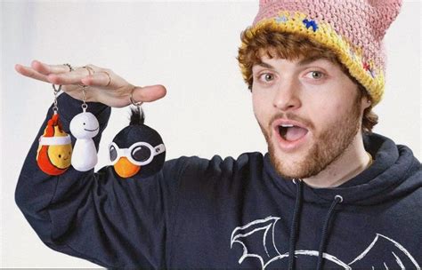 a man wearing a knitted hat and holding two keychains in front of his face