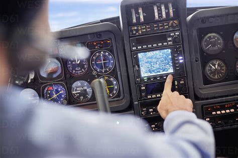 Male pilot using navigational instruments in airplane cockpit stock photo