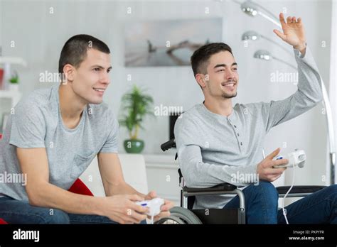 handsome man in wheelchair playing video games Stock Photo - Alamy