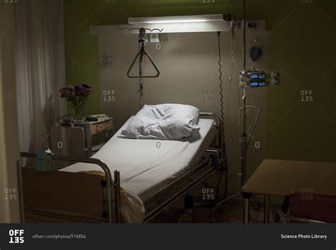 Empty hospital bed at night stock photo - OFFSET