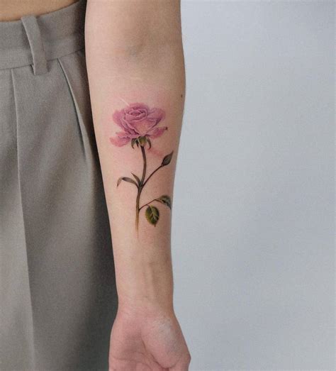 Watercolor pink rose tattoo on the inner forearm.