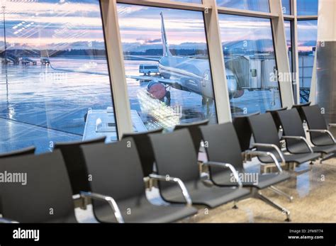 Airport waiting area. plane and dramatic sky behind the windows. Empty ...