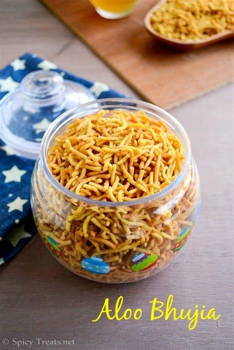 a glass jar filled with noodles on top of a wooden table next to a blue ...