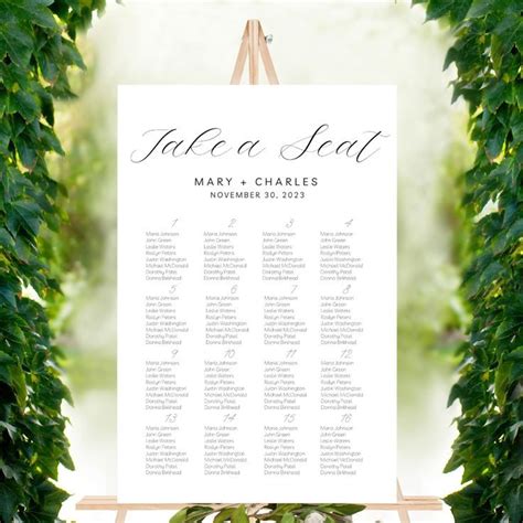 a seating chart for a wedding with greenery around it