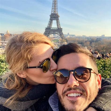 a man and woman taking a selfie in front of the eiffel tower