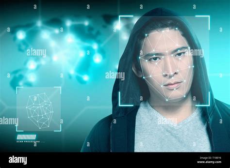 Young asian man in black hoodie using face recognition over digital world map background. Modern ...