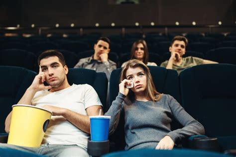 Premium Photo | Man and woman with popcorn in cinema. boring film ...