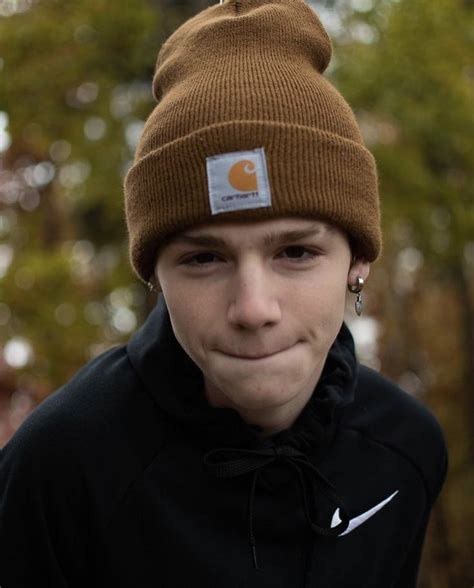 a young man wearing a brown beanie with a white patch on it's forehead