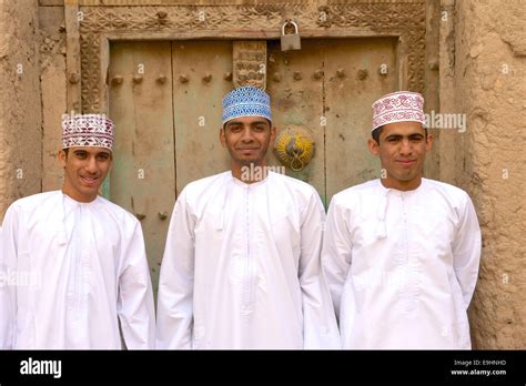 Three young Omani men in traditional dress at the ruins of Birkat Al ...