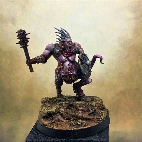 a painted warhammer holding a hammer on top of a rock