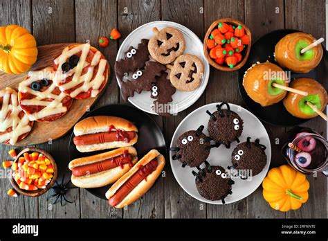 Halloween party food table scene over a rustic wood background ...