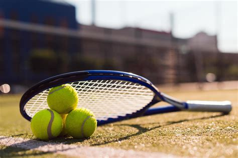 Three tennis balls and racket on hard court under sunlight 3491993 Stock Photo at Vecteezy
