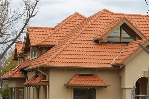 a house with red tile roofing and windows