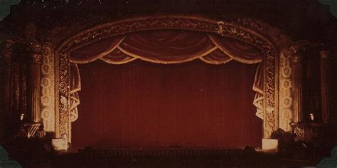 an old photo of a stage with red curtains