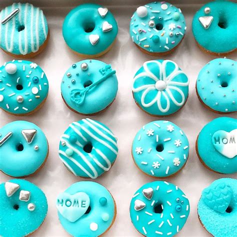a box filled with blue frosted donuts covered in icing