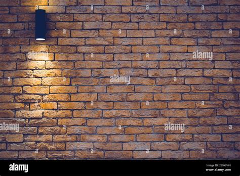 A section of a brown brick wall with an artificial light lamp Stock Photo - Alamy