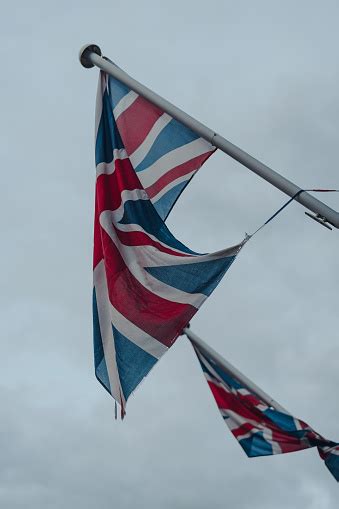 Union Jack Flags On On A Flagpole In Cotswolds Uk Against Grey Sky ...