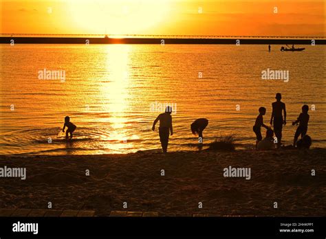 Children splash in Lake Pontchartrain at sunset Stock Photo - Alamy