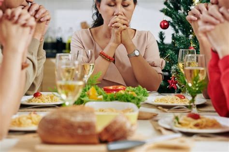 Premium Photo | Family praying at dinner table