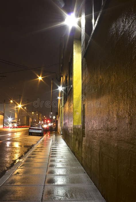 Bright Wet City Sidewalk and Street At Night. Bright wet city sidewalk ...