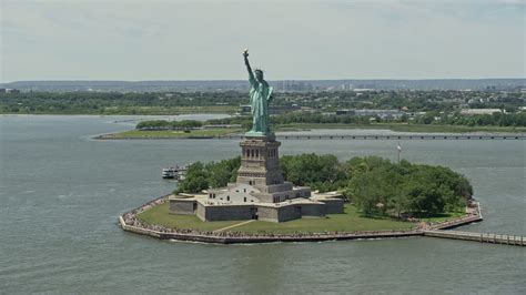 5K stock footage aerial video flying by Statue of Liberty with tourists in New York Harbor, New ...