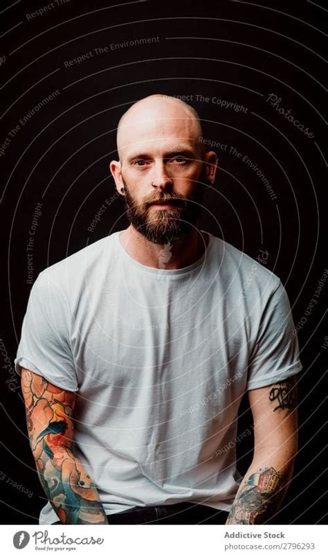 Young bald guy showing tattoos - a Royalty Free Stock Photo from Photocase