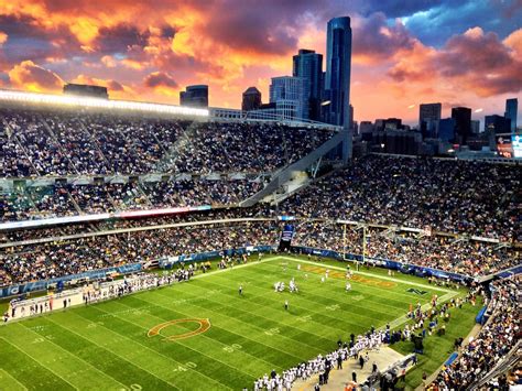 a large stadium filled with lots of people watching a soccer game in the sun set