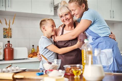 Pleased Senior Woman Embracing Her Grandson and Granddaughter Stock Image - Image of ...