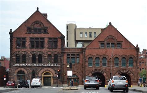 cars are parked in front of an old brick building with arches and arched doorways