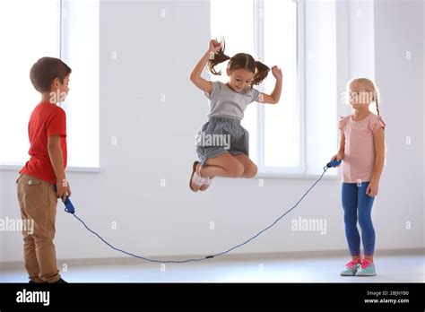 Adorable children skipping rope indoors Stock Photo - Alamy