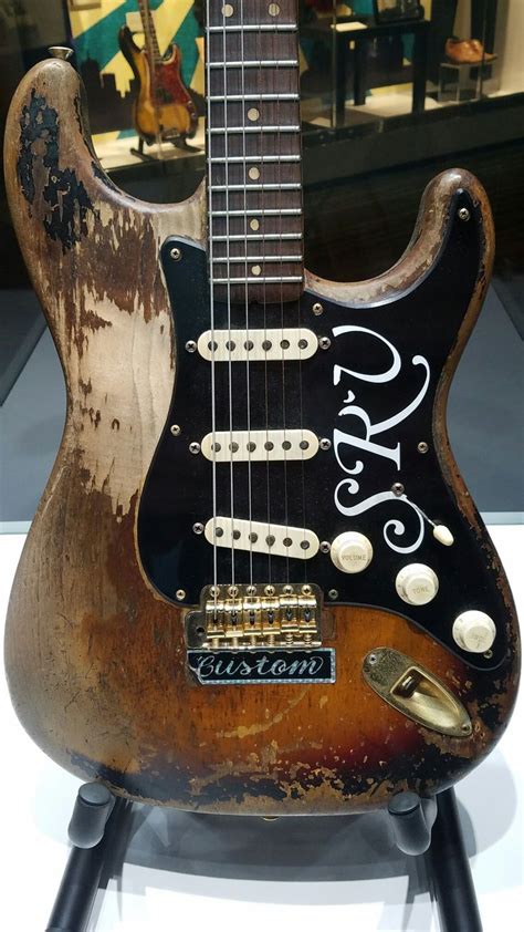 an old guitar is on display in a museum