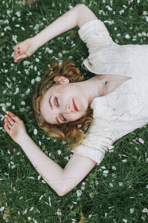 Woman lying down on blossom covered grass, overhead view - Stock Photo ...