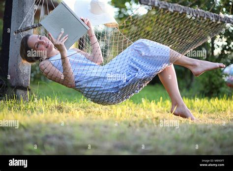 Beautiful young girl lying and reading a book Stock Photo - Alamy