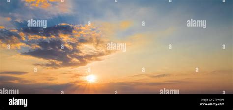 sunset scene with sun fall and ray light, clouds in background, warm colorful sky with soft ...