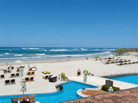 an outdoor swimming pool next to the beach