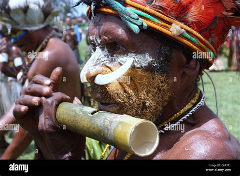 Tribesman in Papua New Guinea playing a bamboo flute Stock Photo - Alamy