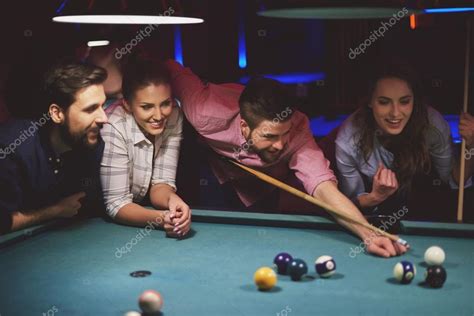 Group of friends playing pool game — Stock Photo © gpointstudio #106172514