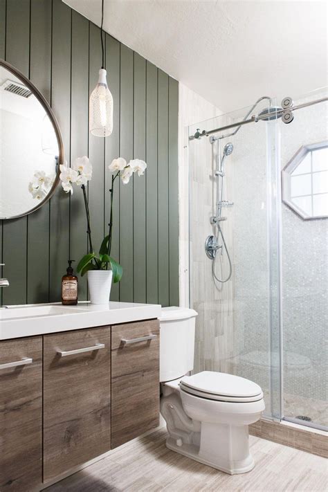 dark green shiplap, reclaimed wood vanity and limestone tile create a natural and modern ba ...