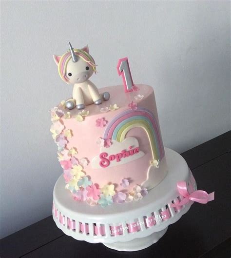 a pink birthday cake with a unicorn on top