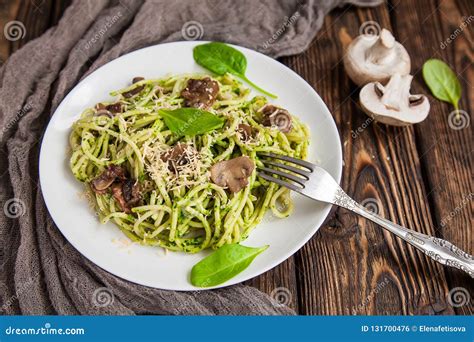 Spaghetti with Spinach Sauce and Mushrooms on a Wooden Table. Close Up Stock Photo - Image of ...