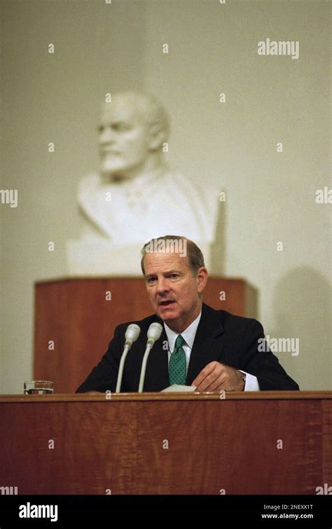 U.S. Secretary of State James A. Baker III, seated before an image of ...