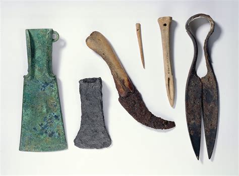 Selection of tools: L-R: early Iron Age bronze axe with bent-over wings ...