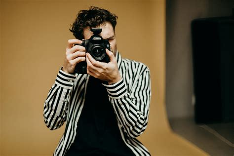 Photo Of Man Holding Black Camera · Free Stock Photo