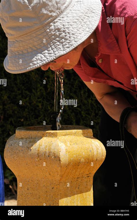 Woman drinking from water fountain Stock Photo - Alamy